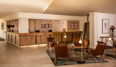 a lobby with a waiting area with chairs and a table at Garden Court Polokwane in Polokwane