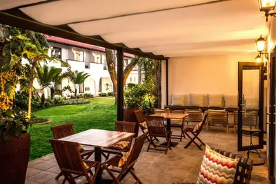 a patio with tables and chairs and a yard at Garden Court Polokwane in Polokwane