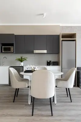 a kitchen with a table and chairs in a kitchen at Menlyn Apartment - Black Marble in Pretoria