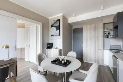 a kitchen and dining room with a white table and chairs at Menlyn Apartment - Black Marble in Pretoria