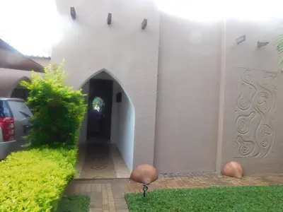 a white building with a hallway leading to a door at Fouriestreet 199 Bed and Breakfast in Mokopane