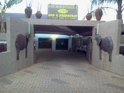 a building with a gate with two animals on it at Fouriestreet 199 Bed and Breakfast in Mokopane