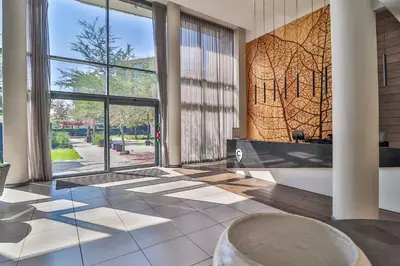 a lobby with a large window and a table at 301 Menlyn Maine Trilogy Apartment in Pretoria