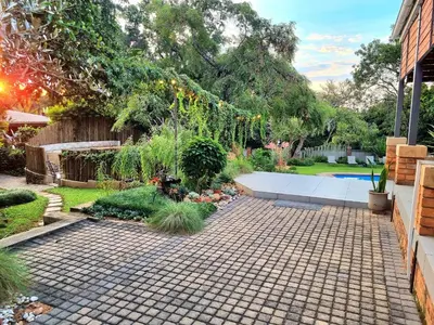 a garden with a brick walkway in a yard at The Coral Tree in Nelspruit