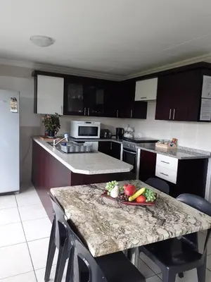 a kitchen with a table with a plate of vegetables on it at Rustic red in Benoni