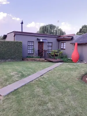 a house with a large orange vase in the yard at Rustic red in Benoni