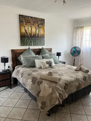 a bedroom with a large bed with pillows on it at Rustic red in Benoni