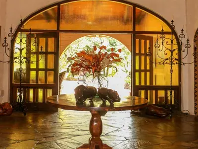 a table with a vase on it in front of a door at Bohm's Zeederberg Country House in Hazyview