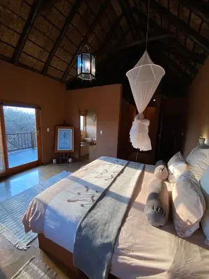 a bedroom with a large bed with a chandelier at Luna rossa 19 Zebula golf course and spa resort in Mabula