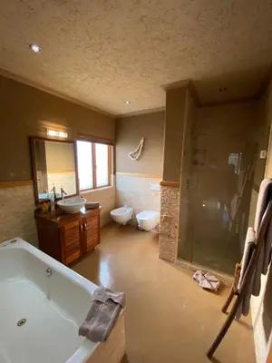 a large bathroom with a tub and two toilets at Luna rossa 19 Zebula golf course and spa resort in Mabula