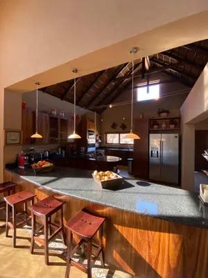 a kitchen with a large counter with stools at Luna rossa 19 Zebula golf course and spa resort in Mabula