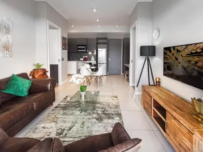 a living room with a couch and a table at Menlyn Apartment - 2 Bedroom Apartment in Pretoria