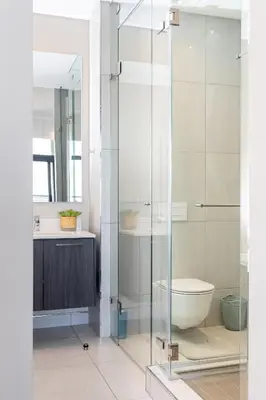 a bathroom with a glass shower with a toilet at Menlyn Apartment - 2 Bedroom Apartment in Pretoria