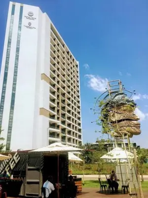 a tall white building with a large building at Menlyn Apartment - 2 Bedroom Apartment in Pretoria