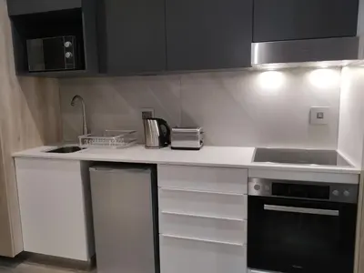 a kitchen with white cabinets and a counter top at Menlyn Residence - Studio Apartment in Pretoria