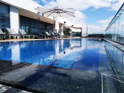 a pool with chairs and an umbrella on top of a building at Menlyn Residence - Studio Apartment in Pretoria