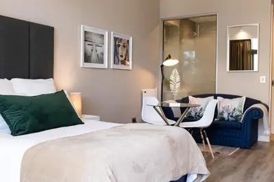 a bedroom with a bed and a table and chairs at Menlyn Residence - Studio Apartment in Pretoria
