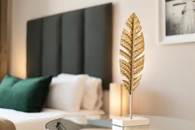 a feather on a table in front of a couch at Menlyn Residence - Studio Apartment in Pretoria