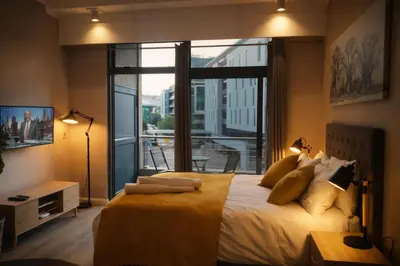 a bedroom with a large bed with a large window at Menlyn Apartment - Studio in Pretoria