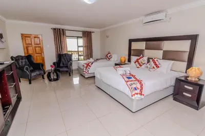 a hotel room with two beds and a television at ASANTE MOUNTAIN LODGE in Hazyview