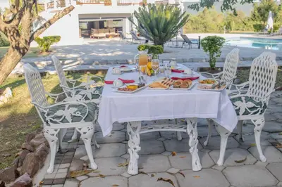 a white table with food on it with chairs at ASANTE MOUNTAIN LODGE in Hazyview