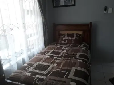 a bed in a bedroom next to a window at Wild Escape in Marloth Park