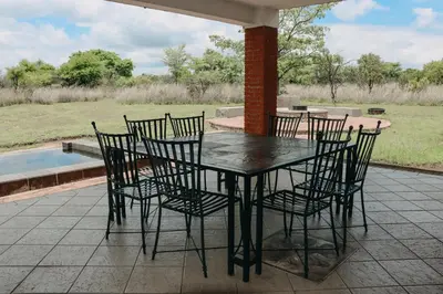a black table and chairs on a patio at 119 Zebula in Mabula