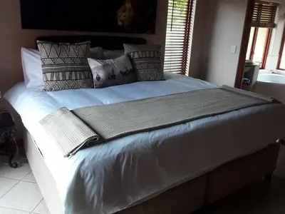 a large bed with blankets and pillows on it at 119 Zebula in Mabula