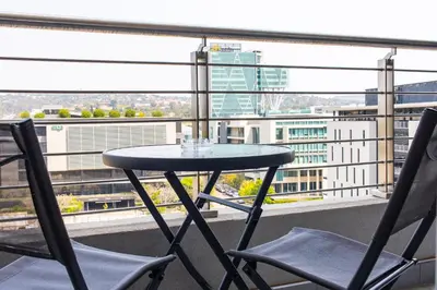 a table and two chairs on a balcony with a view at Menlyn Apartment - Marble Print in Pretoria