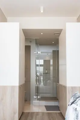 a glass shower in a bedroom with a bed at Menlyn Apartment - Marble Print in Pretoria