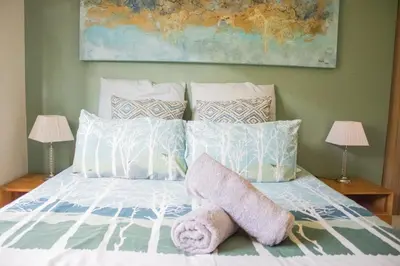 a bedroom with a bed with pillows and a painting at 150 The Blyde Crystal Clear Lagoon 3 Bedroom Garden Apartment in Pretoria