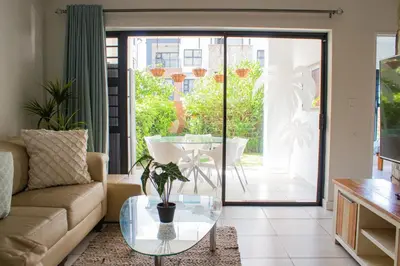 a living room with a couch and a glass table at 150 The Blyde Crystal Clear Lagoon 3 Bedroom Garden Apartment in Pretoria