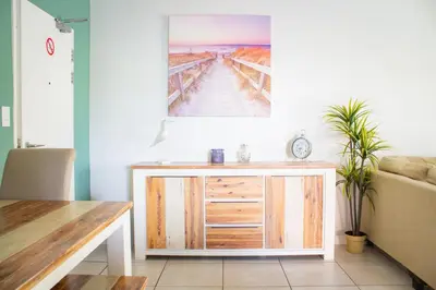 a living room with a wooden cabinet and a painting on the wall at 150 The Blyde Crystal Clear Lagoon 3 Bedroom Garden Apartment in Pretoria