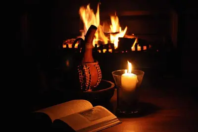 a bottle of champagne next to a book and a candle at Amohela Guesthouse in Midrand