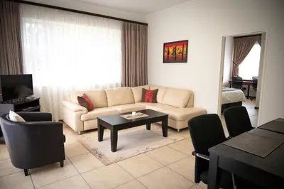 a living room with a couch and a table at Amohela Guesthouse in Midrand