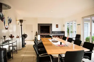 a dining room with a table and chairs and a fireplace at Amohela Guesthouse in Midrand