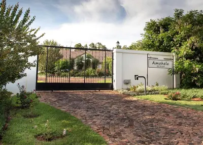 a gate in a garden with a driveway at Amohela Guesthouse in Midrand