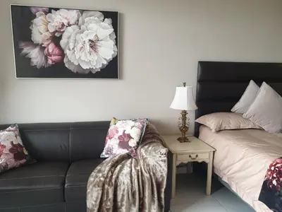 a living room with a couch and a table with a lamp at Menlyn Maine in Pretoria
