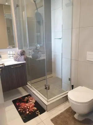 a bathroom with a shower and a toilet at Menlyn Maine in Pretoria