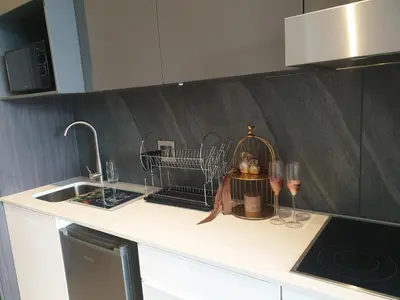 a kitchen counter with a dish rack and wine glasses at Menlyn Maine in Pretoria