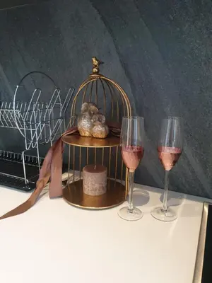 a table with two glasses of wine and a bird cage at Menlyn Maine in Pretoria