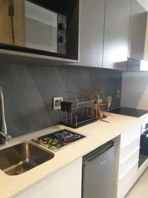 a kitchen counter with a sink and a microwave at Menlyn Maine in Pretoria