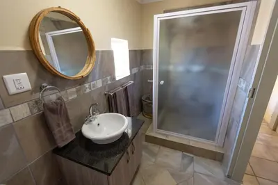 a bathroom with a sink and a shower at The Bushveld Farmhouse in Mabalingwe Nature Reserve in Warmbaths