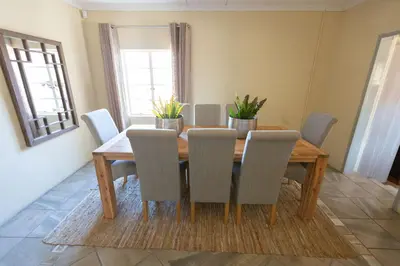 a dining room with a wooden table and chairs at The Bushveld Farmhouse in Mabalingwe Nature Reserve in Warmbaths