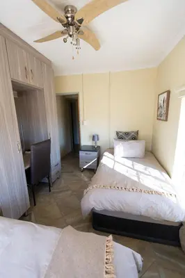 a bedroom with two beds and a ceiling fan at The Bushveld Farmhouse in Mabalingwe Nature Reserve in Warmbaths