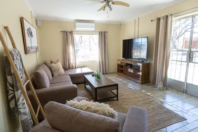 a living room with a couch and a tv at The Bushveld Farmhouse in Mabalingwe Nature Reserve in Warmbaths