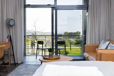 a bedroom with a bed and a view of a balcony at Menlyn Residence in Pretoria