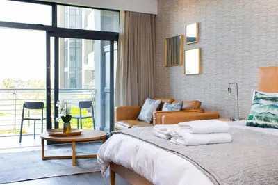 a bedroom with a bed and a living room at Menlyn Residence in Pretoria