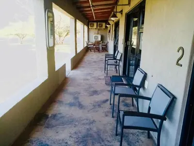 a row of chairs sitting on the side of a building at Tula Baba Game Lodge in Brits