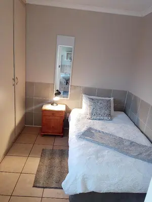 a small bedroom with a bed and a mirror at Accommodation@Park1285 in Pretoria